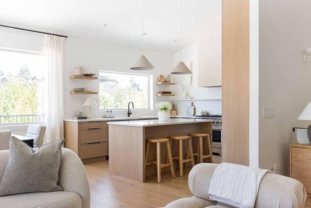 Bright open concept kitchen with floating shelves and wooden accents