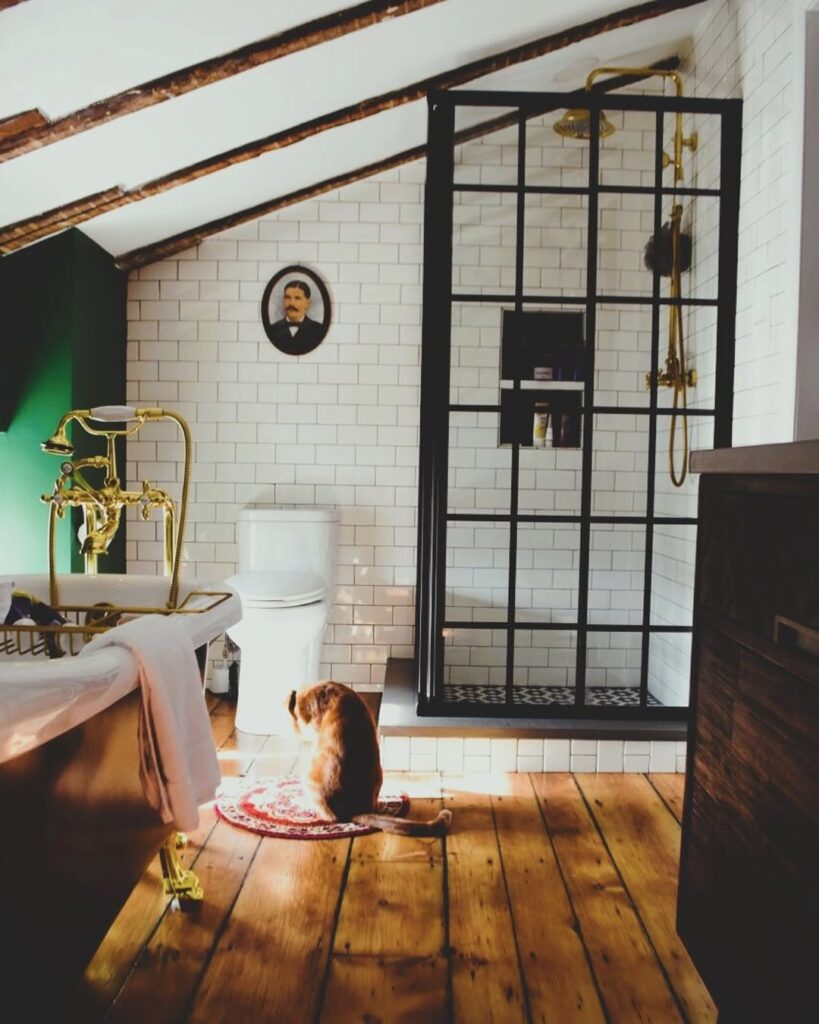 Attic bathroom with exposed beams and black framed shower