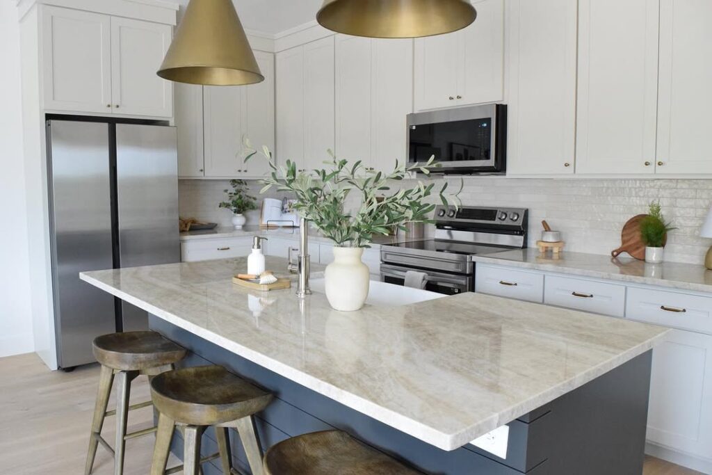 White kitchen with brass pendants and wooden bar stools