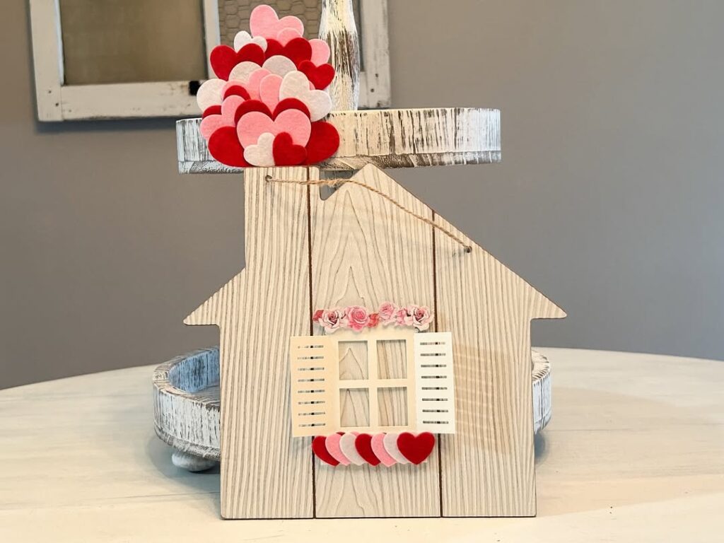 Wooden house shaped decor with layered valentines hearts and shutters