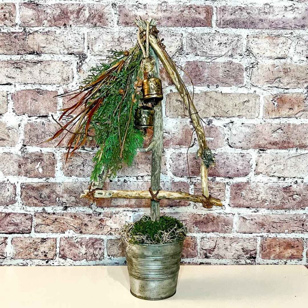 Twig bell display with evergreen sprigs in galvanized planter