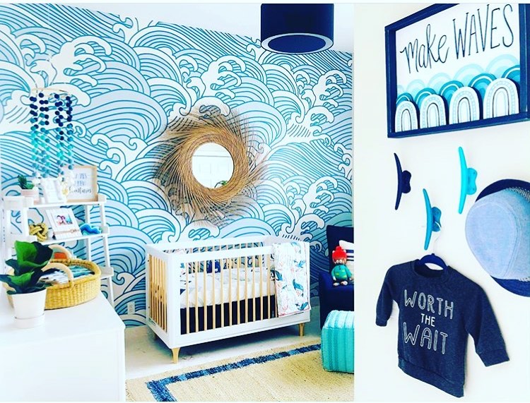 Ocean themed nursery with wave wallpaper wooden crib and nautical decor