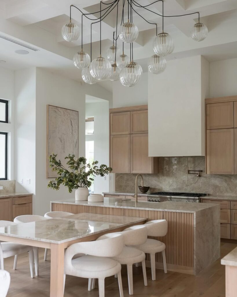 Modern kitchen with glass globe lights wood cabinets and white stools