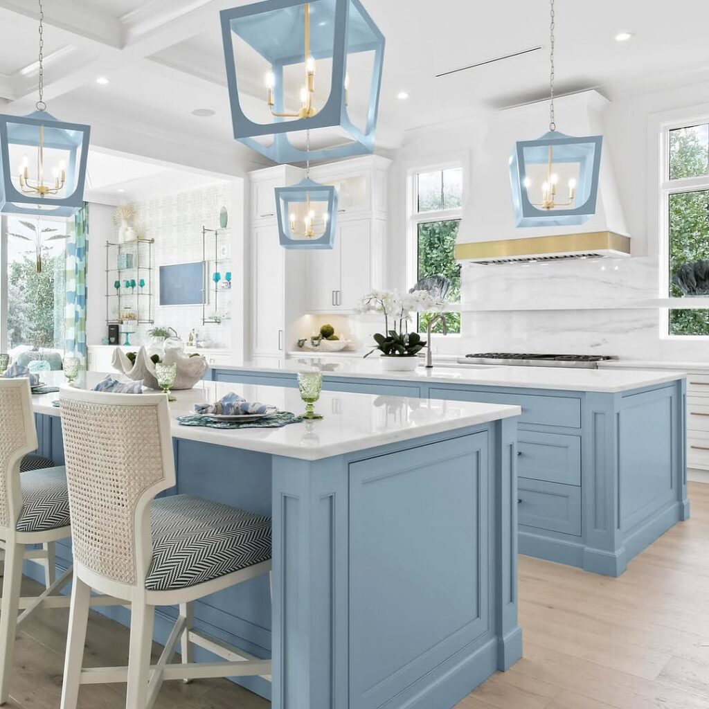 Blue kitchen with lantern pendants cane chairs and white marble backsplash