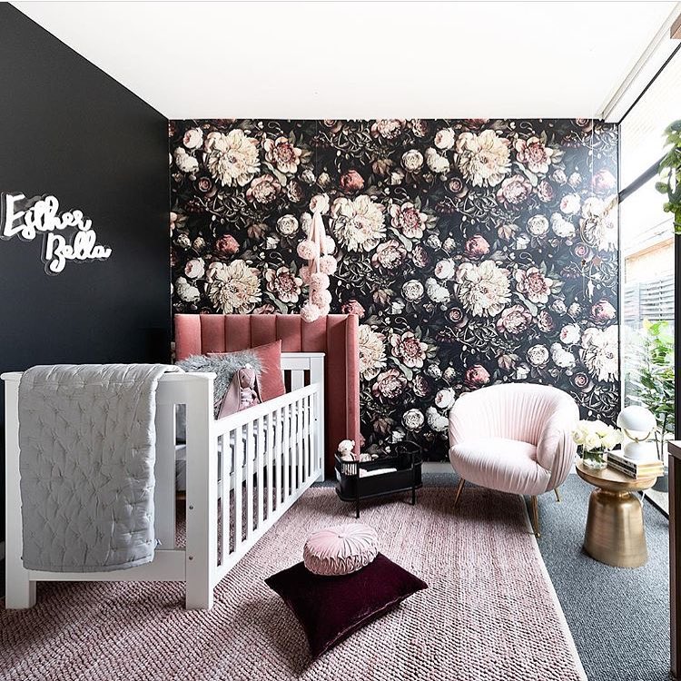 Modern nursery with black floral wallpaper pink velvet details and white furniture