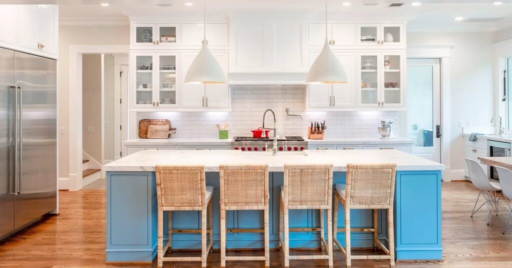 White and blue kitchen with rattan barstools and subway tile backsplash