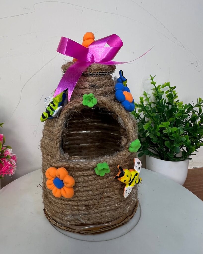 Twine wrapped beehive with clay bees and flowers