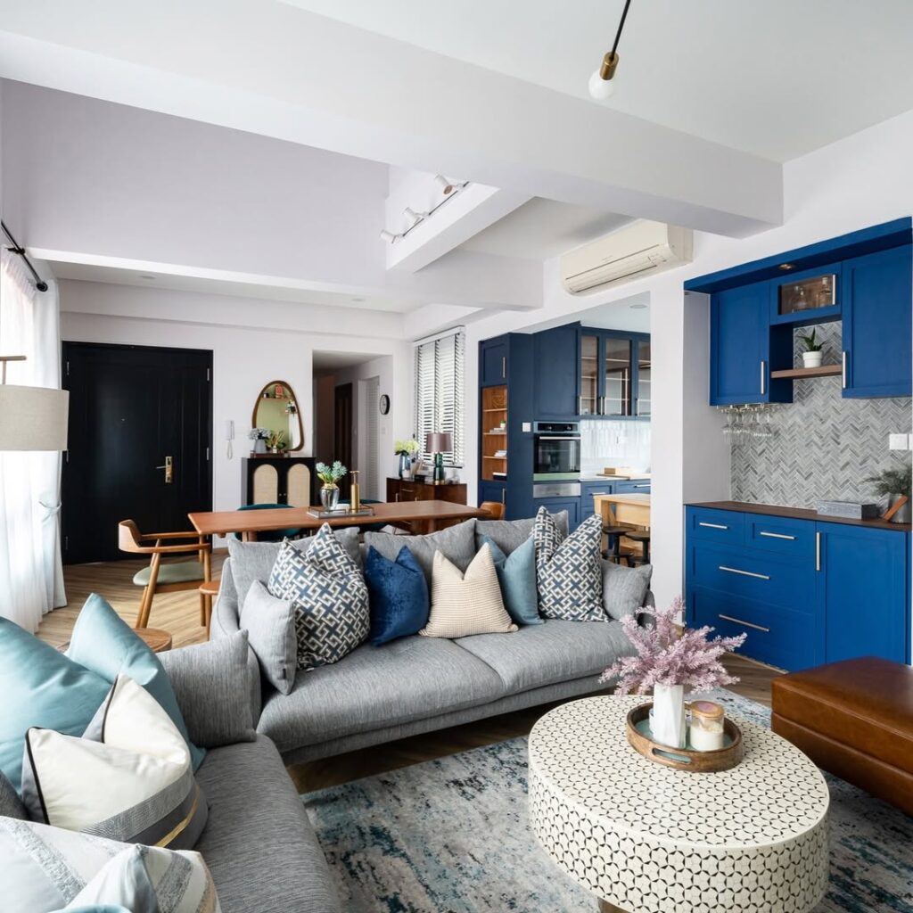 Modern living room with blue kitchen gray sectional and geometric pillows