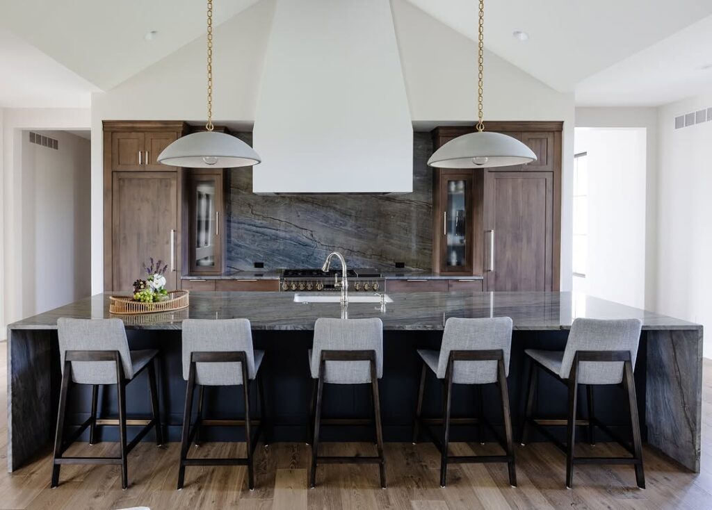 Kitchen with vaulted ceiling stone backsplash and dome pendants