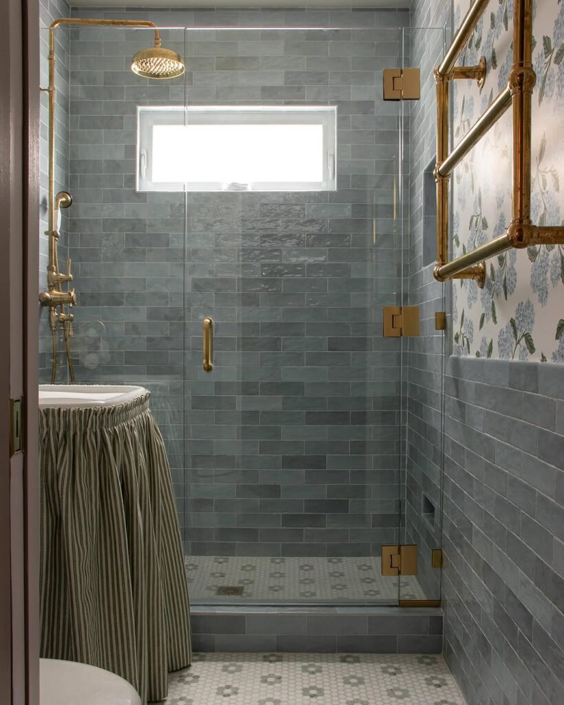  Bathroom with blue tiles and brass fixtures featuring glass shower