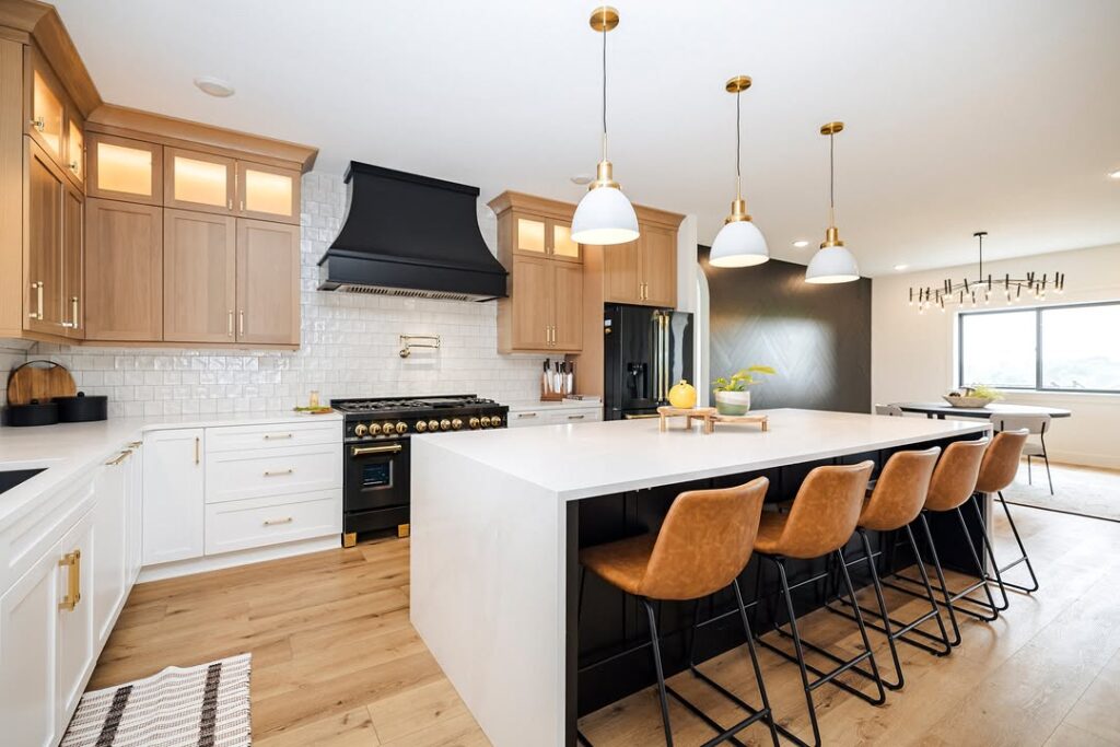 Kitchen with oak cabinets white surfaces and leather barstools