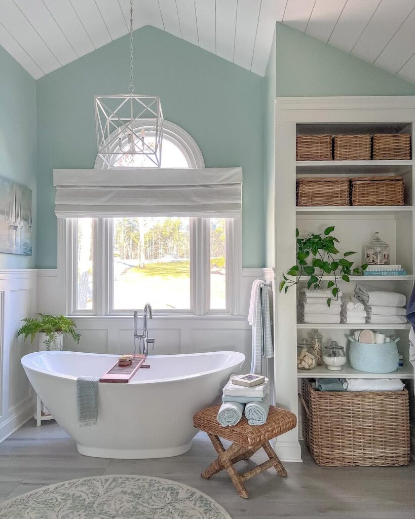 Coastal bathroom with sage walls and organized storage