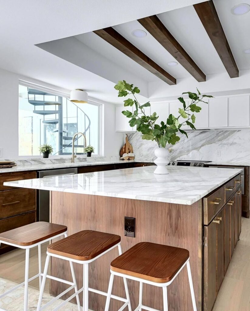 Modern kitchen with white cabinets wooden beams and marble surfaces