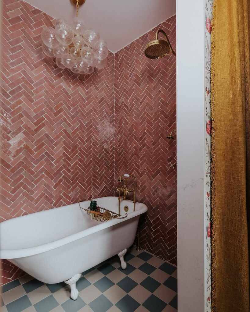 Pink bathroom with herringbone tiles and bubble chandelier