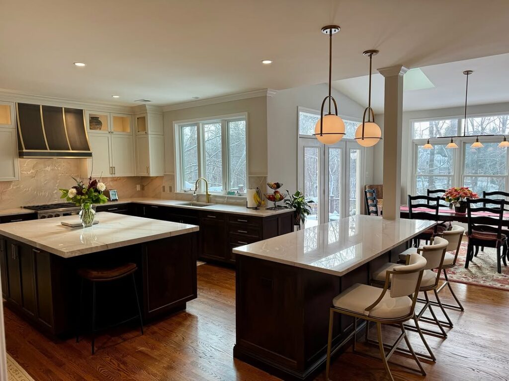 Kitchen with dark and white cabinets multiple islands and winter views