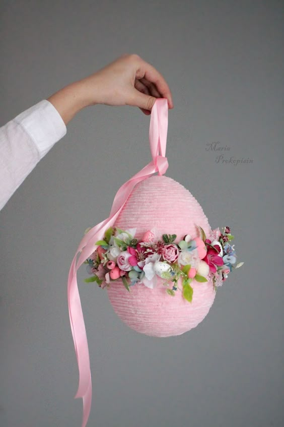 Pink paper lantern decorated with floral arrangement and ribbon