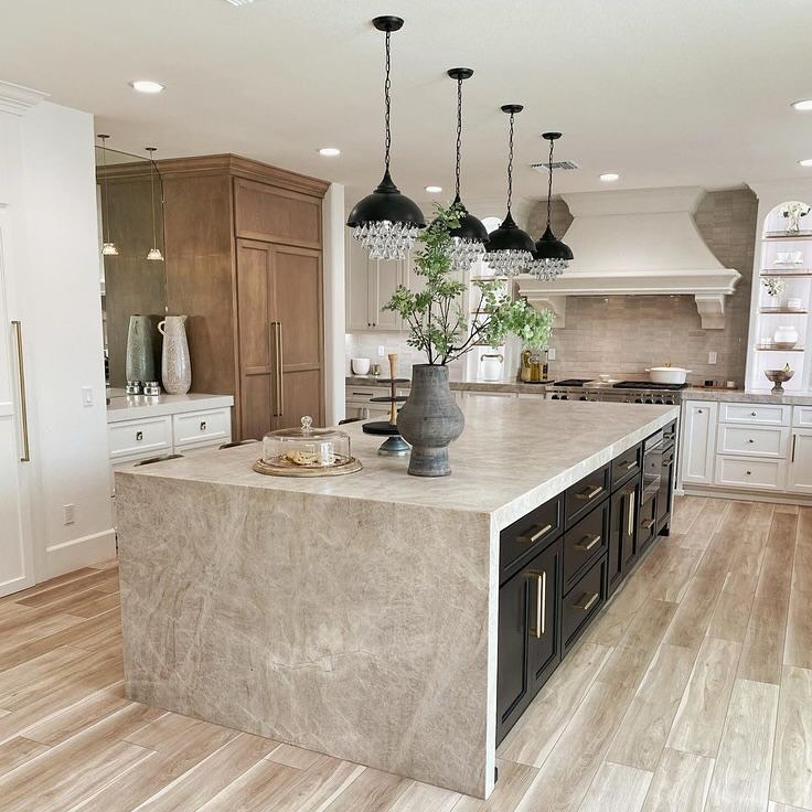 Modern kitchen with crystal pendants quartzite waterfall island and wood accents