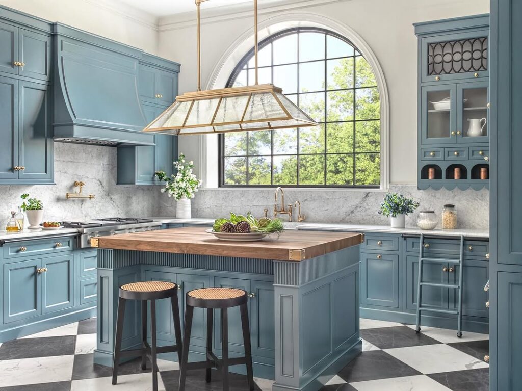 Blue kitchen with arched window butcher block island and checkerboard flooring