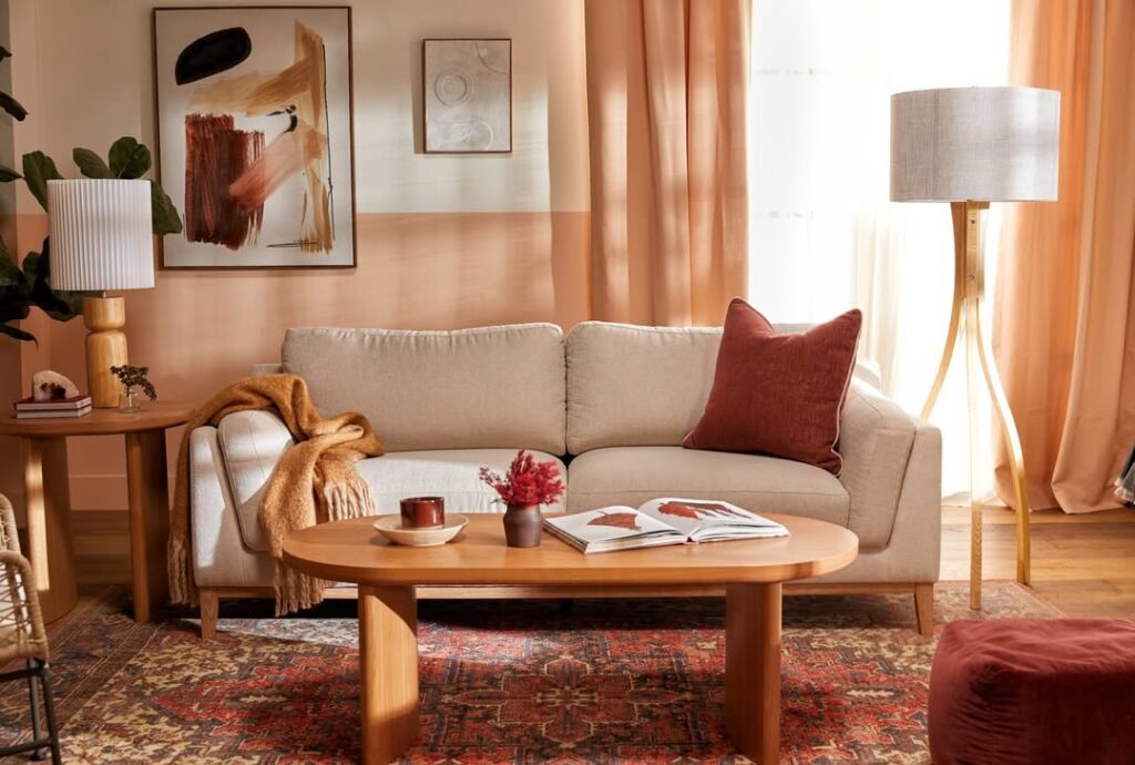 Beige sofa with terracotta accents abstract art and wooden coffee table