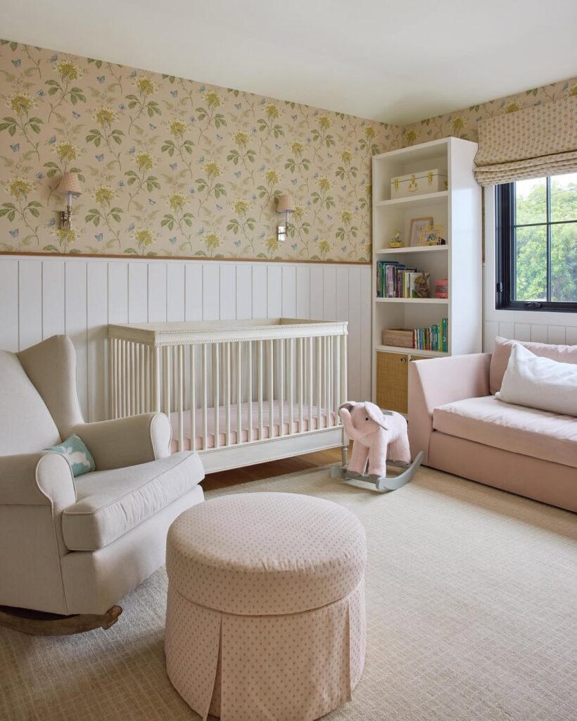 Nursery with floral wallpaper white wainscoting and cream colored furniture