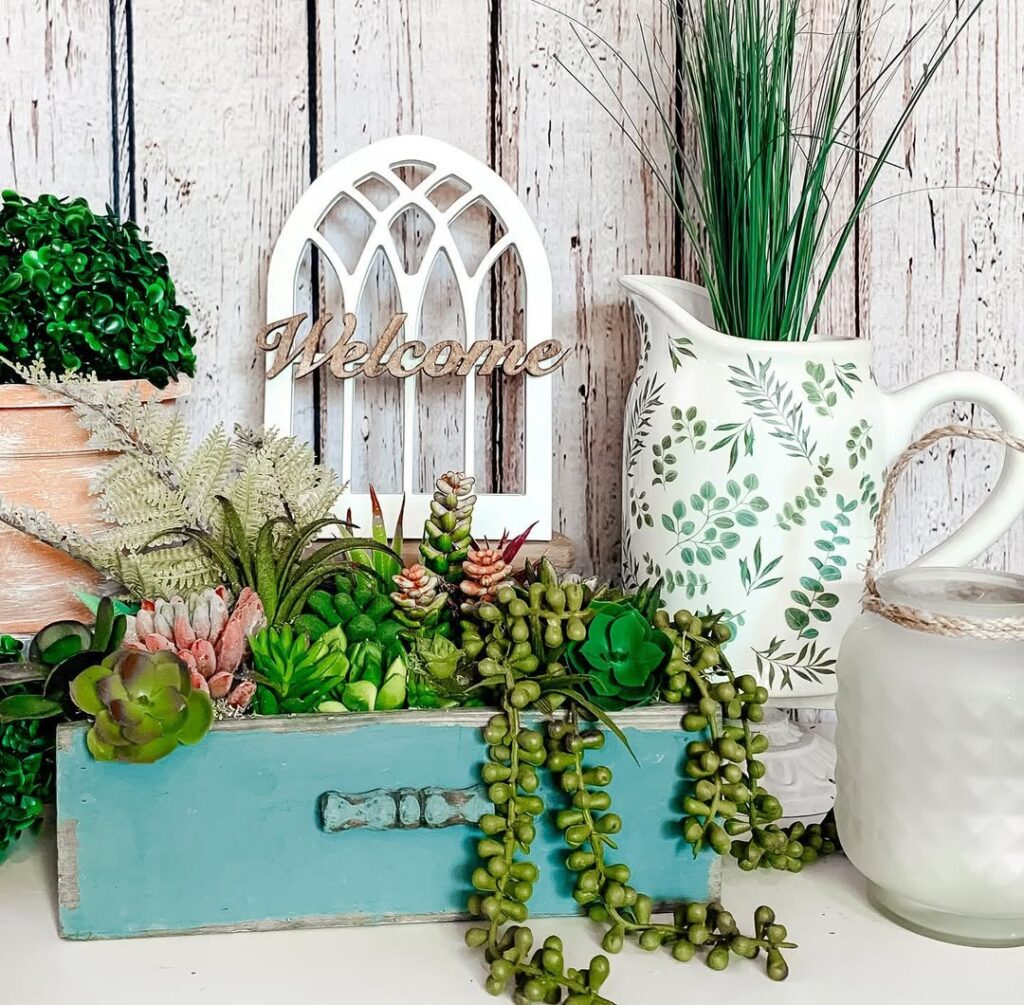 Blue wooden box with succulents white window frame and botanical pitcher